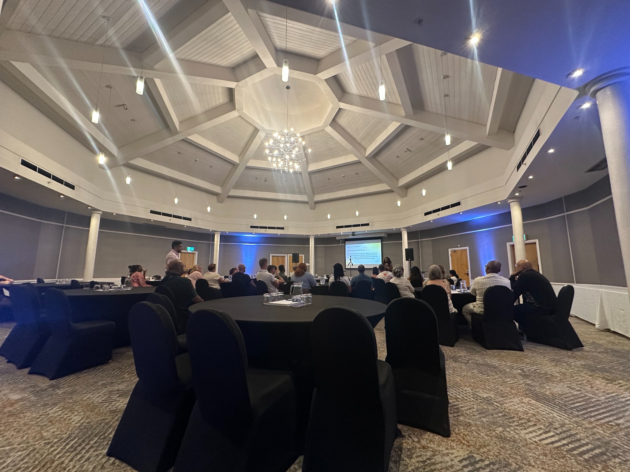 Conference room arranged with presentation screens and event lighting